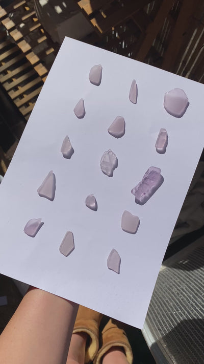 Flatlay of assorted lavender sea glass pieces for custom handmade ring design in Australia
